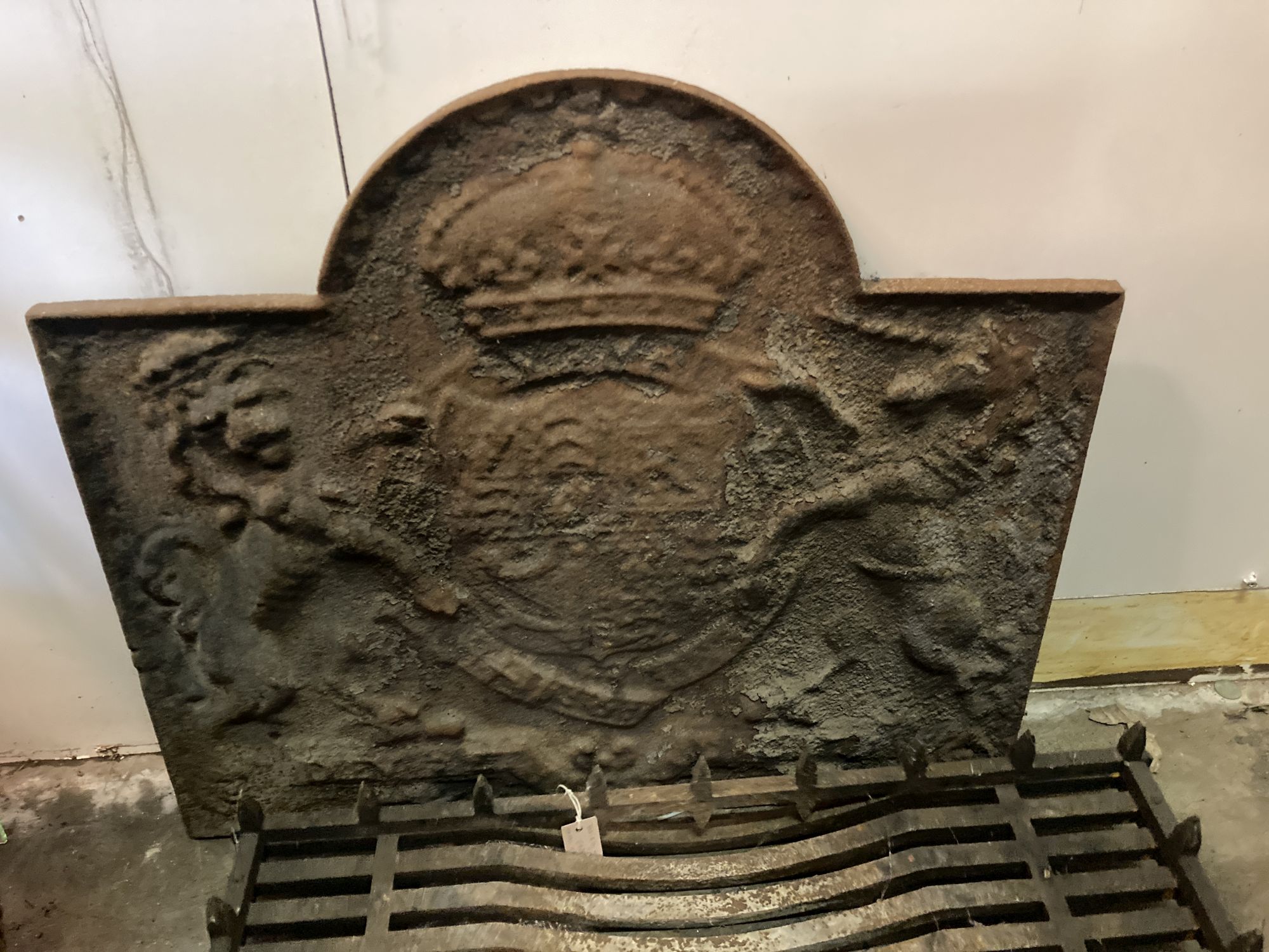 A 17th century style cast iron fire back, width 87cm, height 74cm and an iron grate (2)